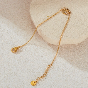 Detailed view of gold crown charm bracelet with pavé rhinestones on textured stone