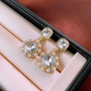 Macro detail of French vintage square earrings with pearls and crystals in a gift box