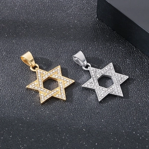 Macro detail of gold and silver hexagram pendants with shimmering crystal inlay