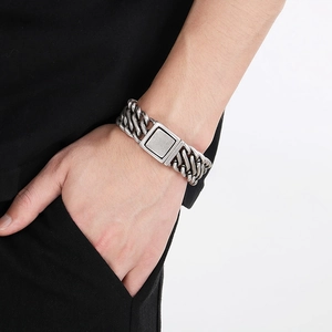 Detail of vintage silver titanium steel cuban link bracelet with square buckle on wrist
