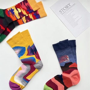 Three pairs of French artistic crew socks with colorful jacquard patterns on white background