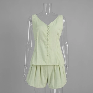 Detail of pleated high-waisted shorts and fabric texture in light green cotton set