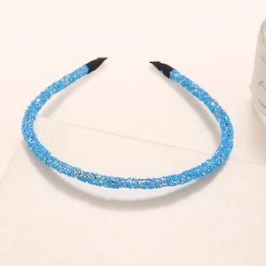 Detail of a thin blue glitter headband with sparkling sequins and black anti-slip ends