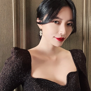 Elegant cat eye stone leaf drop earrings in gold with a white shell finish on a model
