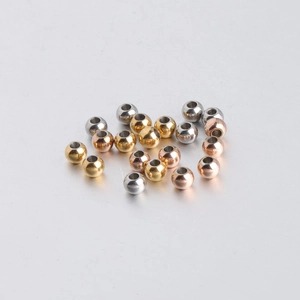 Macro shot of 5mm stainless steel spacer beads in gold, silver, and rose gold finishes