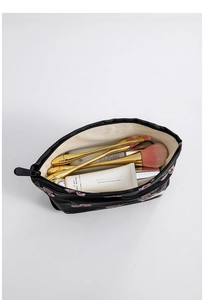 Detail of floral makeup bag showing large capacity with brushes and hand cream inside