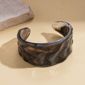 Detailed macro of vintage acrylic cuff bracelet featuring ink marble texture and waves