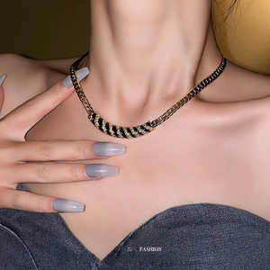 Collana vintage placcata in oro con ciondolo a righe nere e strass indossata da una modella