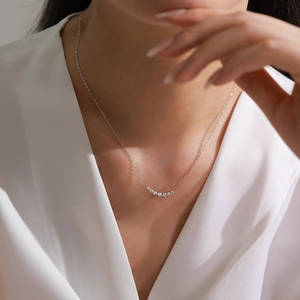 Elegant S925 silver curved smile necklace with shimmering zircons on a female model