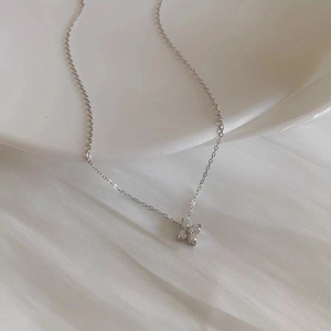 Macro shot of S925 sterling silver four-leaf clover necklace with sparkling zircon stones