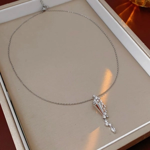 Detail of silver hourglass pendant necklace with sparkling zircons in a jewelry box