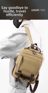 Detail of khaki washed canvas backpack with leather straps and metal buckle accents
