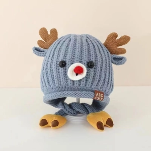 Close-up of blue baby knit hat with elk antlers and a brown ABC CHI fabric label