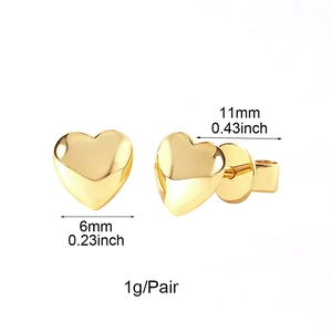 Macro detail of gold heart earrings with 6mm x 11mm dimensions and minimalist style