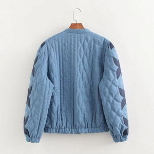 Detail of the blue quilted jacket back featuring a diamond stitch pattern and elastic hem