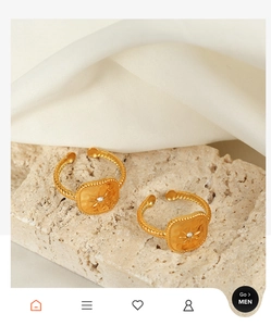 Detailed view of gold plated geometric rings with starburst engraving and crystals on stone