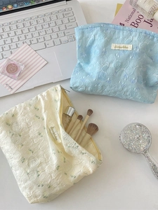 Floral jacquard rose cosmetic bag in blue and beige with textured embossed details