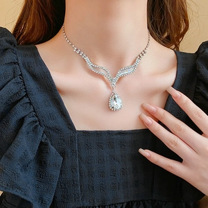 Gros plan d'un collier en V avec un grand strass en forme de goutte sur un mannequin