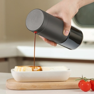 Leak-proof glass oil dispenser bottle with black matte finish and red precision pourer