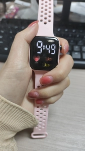 Pink LED sports watch display showing heart rate, calories and step tracking metrics
