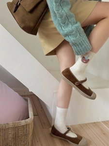 Detail shot of brown corduroy Mary Jane shoes with cream bear pattern crew socks