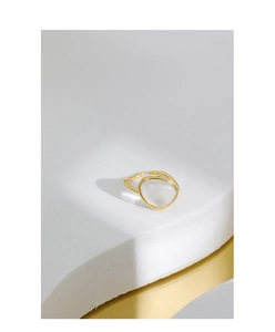 Detailed close-up of golden minimalist open ring with inlaid transparent moonstone crystal