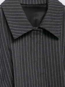 Detail eines grauen vertikal gestreiften Blazers mit Revers und strukturierter Textur