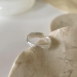 Macro shot of S925 sterling silver ring with irregular hammered texture and hallmark