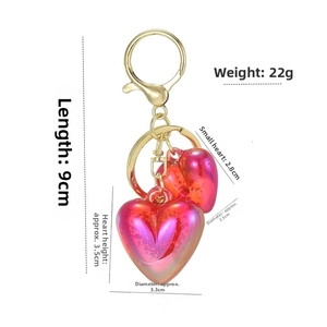 Detail view of red heart acrylic keychains with dimensions of 9cm length and 22g weight