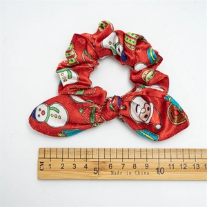 Red Christmas scrunchie with bow featuring Santa and snowman patterns on white background