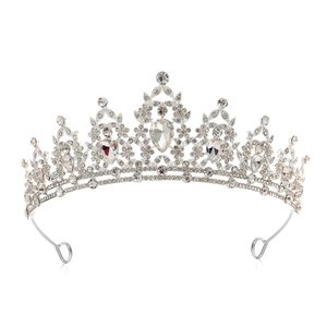 Detail of silver bridal crown featuring intricate filigree and teardrop rhinestone