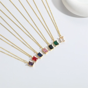 Close-up of elegant gold necklaces with square colorful zircon pendants in seven shades