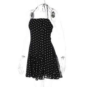 Detail view of black polka dot halter neck mini dress with ruffled hemline