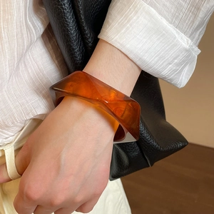 Detail of amber translucent resin bracelet with geometric facets on a wrist