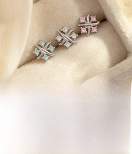Detailed view of titanium steel cross stud earrings with zircon in a velvet jewelry box