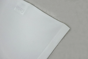 Detail shot of white ribbed fabric with premium double-stitch hem and knit texture