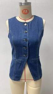 Macro detail of dark blue denim vest with metal buttons and slim fit waist cut