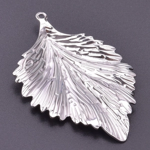 Macro shot of stainless steel leaf pendant with detailed vein texture and silver finish