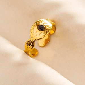 Macro shot of gold adjustable 304 stainless steel ring with black gemstone and hammered texture