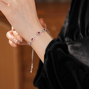Makroaufnahme eines verstellbaren Zirkon-Armbands mit einem ovalen roten Edelstein