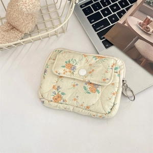 Detail of floral quilted card wallet with snap button pocket and metal zipper puller