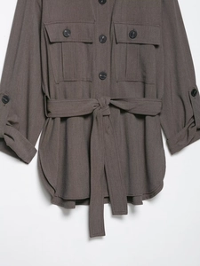 Détail d'une veste chemise utilitaire marron avec double poche et ceinture à la taille