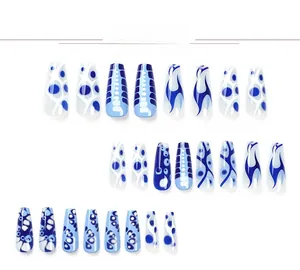 Detail of blue and white coffin press-on nails with flame and abstract marble patterns