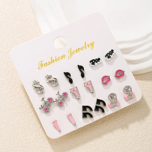 Close-up of nine pairs of enamel stud earrings with musical and fashion motifs on a card