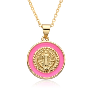 Detail of pink enamel round pendant with gold religious relief on a necklace