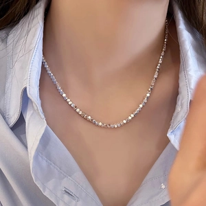 Vue détaillée macro d'un collier à perles argentées scintillantes sur un mannequin