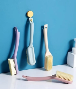 Detail showing set of four colorful soft bristle shoe brushes with hanging holes and long handles