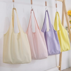 Minimalist canvas tote bags in four macaron colors hanging on a wooden rack