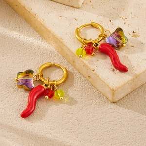 Gold hoop earrings with red chili and rainbow butterfly charms on beige stone surface
