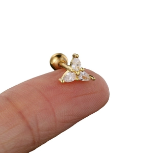 Minimalistischer goldener Zirkon-Ohrstecker in Birnenform auf der Fingerspitze